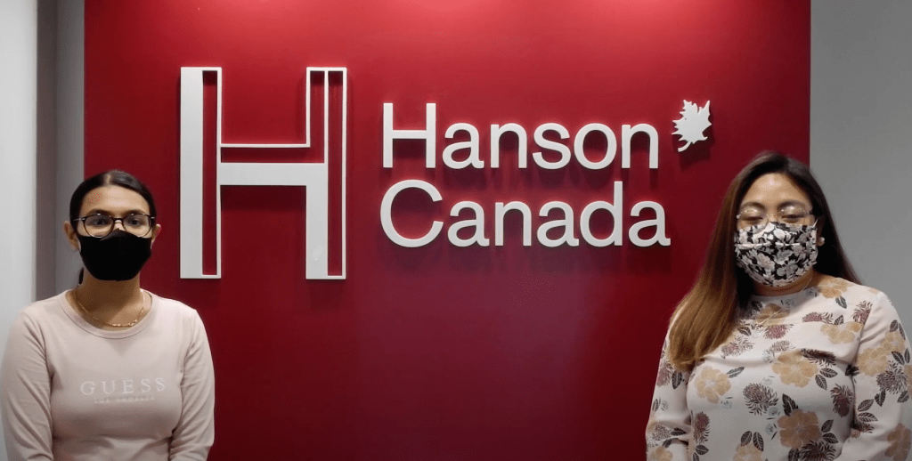 Two women in front of Hanson Canada office displaying COVID-19 protocols
