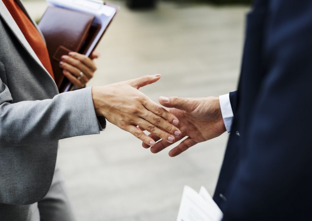 Corporate woman and man shaking hands in a partnership