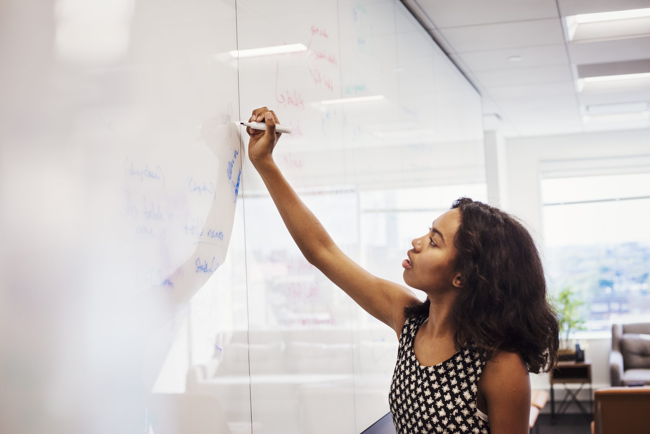 Woman writing on whiteboard